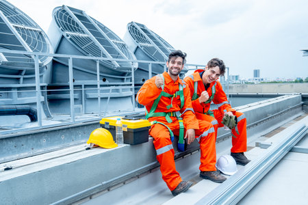 Two engineer or technician worker sit together to relax after finish their work and look at camera with smiling and show action of happy to work.の写真素材