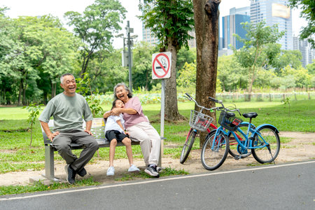 Senior woman hug with love to girl and sit on garden bench beside of senior man to relax after ride...