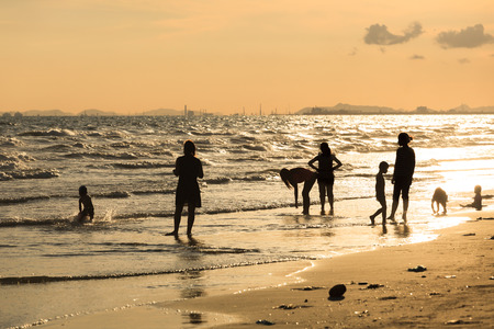Happy Family Playing on the Beach at Sunriseの写真素材