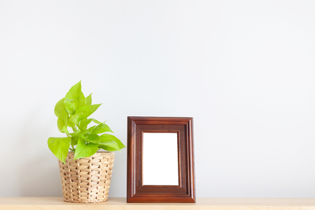 Golden pothos and photo frame on wood tableの写真素材