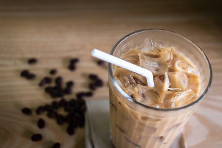 Cold brewed iced coffee in glass and coffee beans on wood tableの写真素材