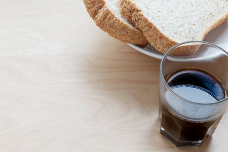 Breakfast coffee and sliced bread on tableの写真素材