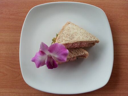 Sandwich on a white dish with pink orchidの写真素材