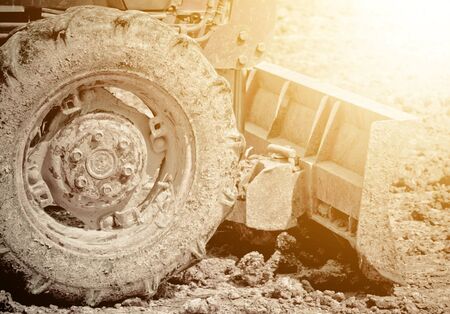 The wheeled tractor has mud attached to the tire. Heavy duty machineの写真素材