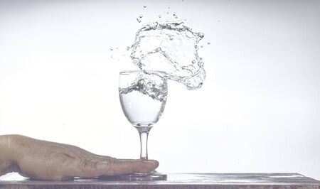 A glass of water spilled Splash on the tableの写真素材