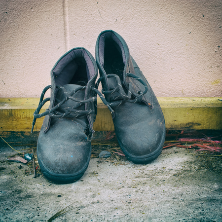 Dirty old shoes on Dirty floorの写真素材