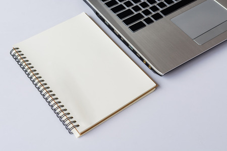 Notebook with computer on white table