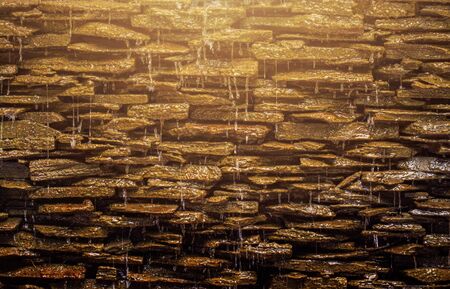 waterfall with sunset light on stone backgroundの写真素材