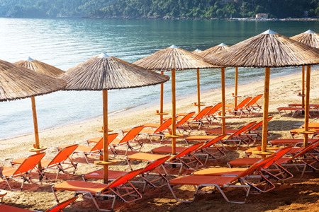 Group of sunbeds and sunshades at the beach の写真素材