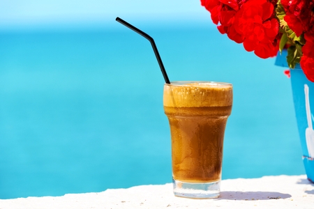 Ice coffee against sea background の写真素材