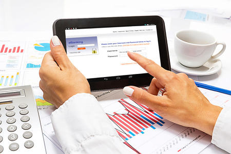Businesswoman pointing on tablet, inside bright office の写真素材