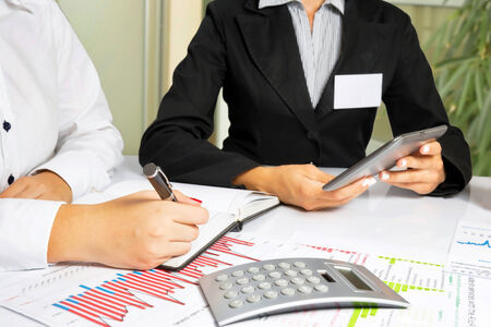 Business women doing annual report, at office desk の写真素材