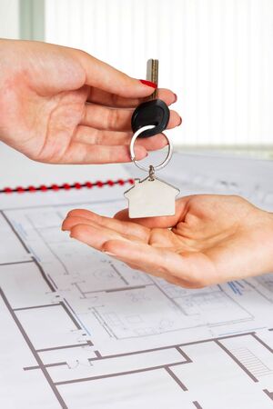 Close up of female architect hand,handing over house key to a customer の写真素材