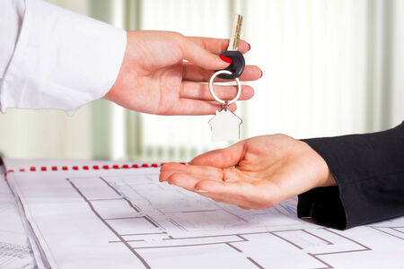 Architect hand presenting house key to a client の写真素材