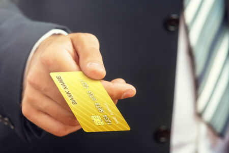 Close up of a businessman s hand,holding gold credit card の写真素材