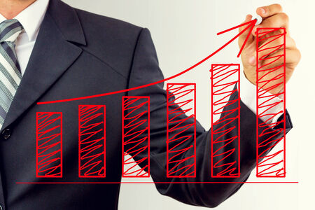 Young businessman, drawing business graph on board, isolated on white background の写真素材