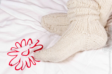 Legs in knitted warm socks, on bed の写真素材