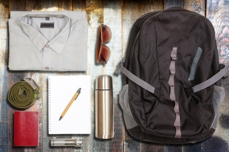 Several hiking items, on top of rustic wooden table 