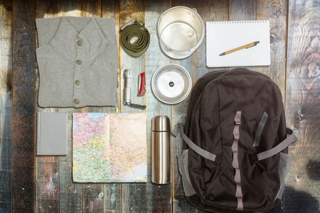 Several hiking items, on top of rustic wooden table 