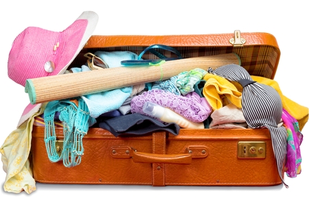 Retro suitcase, full of clothes and vacation items, isolated on white .の写真素材