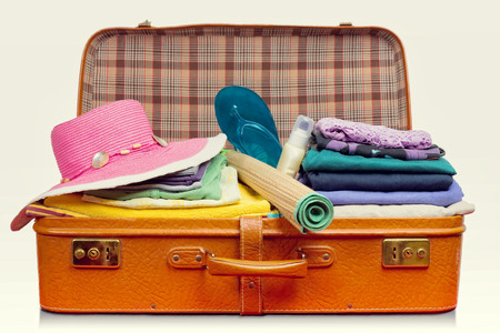 Packed vintage suitcase full of vacation items.の写真素材