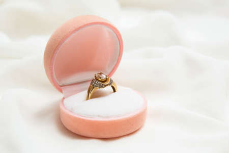 Golden ring inside ring box on the white satin.の写真素材