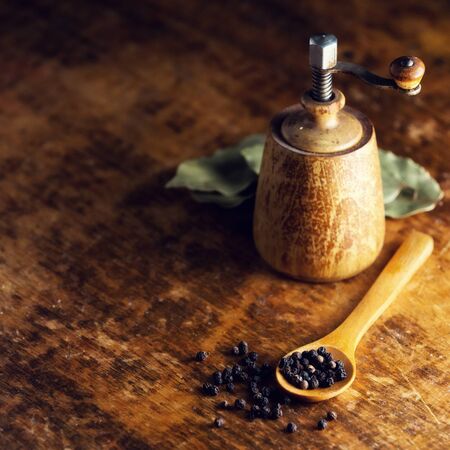 Whole pepper grains on wooden table.の写真素材