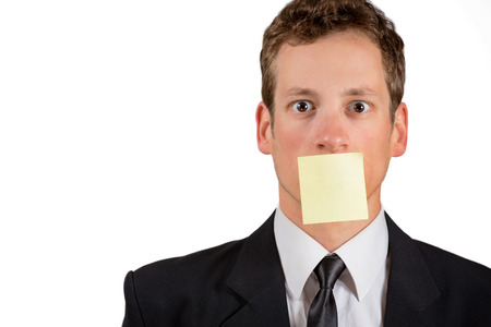 Young businessman with blank note on his mouth, isolated on white background.の写真素材