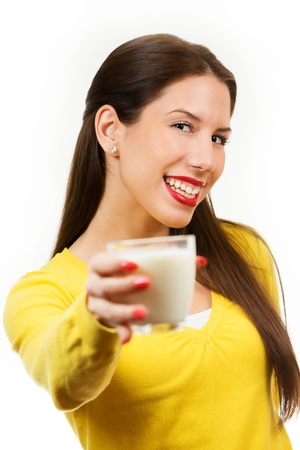Cute young woman drinking milk, isolated on white background.の写真素材