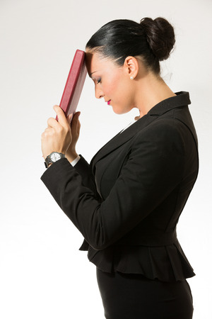 Black hair business dressed woman holding red bookの写真素材