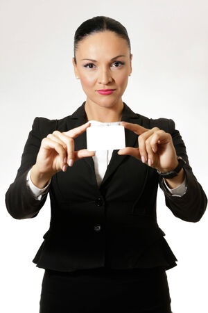 Business dressed woman, smiling and showing white card.の写真素材