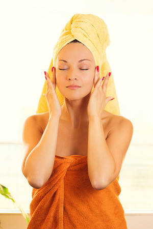 Beauty young woman, with towel on head, enjoining in treatment.の写真素材