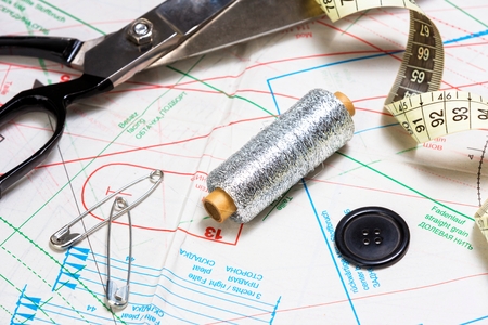 Close up of silver sewing thread,scissors and measure tape.