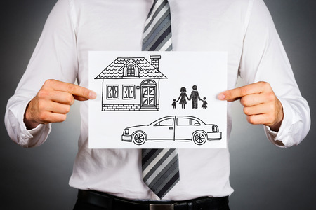 Close up of a business manholding white card with housecar and family drawing inside.Isolated against grey background.の写真素材