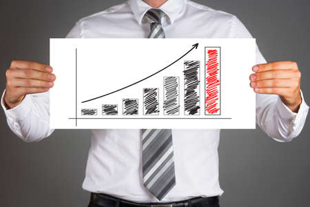 Young businessman presenting success. Male hands holding drawn business graph.の写真素材