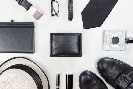 Men accessories. Black elegant accessories pieces isolated on white wooden table. Top view.の写真素材