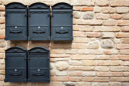 Several wall mounted mailboxes on the brick wall.の写真素材