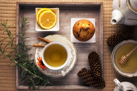 Winter tea time. Lovely arranged cup of tea next to tea ingredients,  on top of the wooden tray.の写真素材