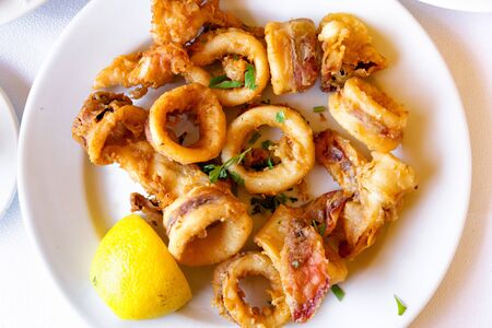 Top view of seafood meal. Fried squids with slice of lemon.の写真素材