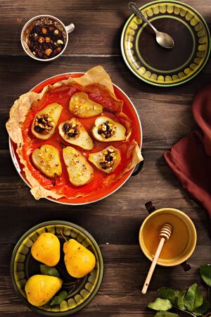 Top view of served dessert table. Baked pears with mixed nuts and honey.の写真素材