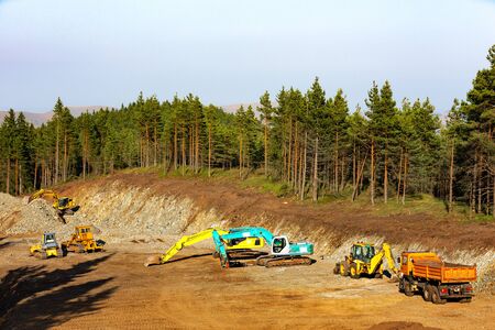 Heavy-duty construction machines at construction site, high in the mountain.