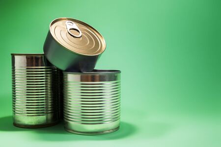 Various cans of food isolated against green background, with available copy space.の写真素材