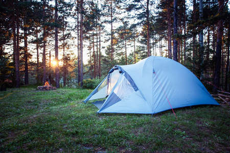 Camping tent in the mountain forest at sunrise.の写真素材