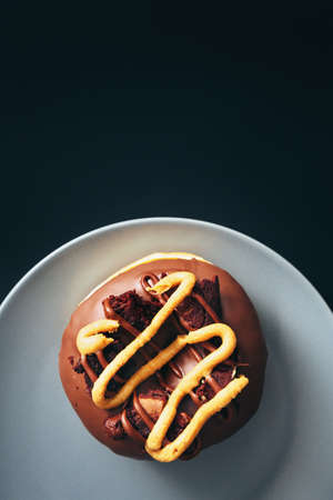 Chocolate donut inside served gray plate with negative space above it.の写真素材