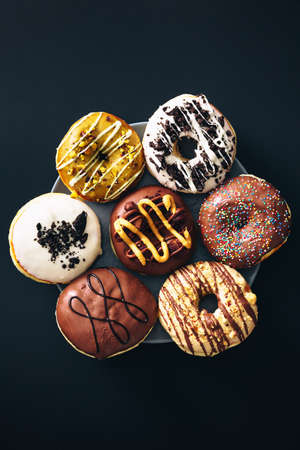 Top view of group of chocolate donuts, served on top of dark background.の写真素材