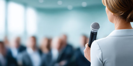 Smart business presentation in city conference room with speaker holding microphone promoting sustainable ideas and growthの素材