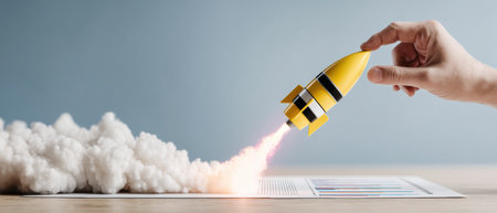 Hand holding yellow rocket launching from document graph symbolizing business growth and startup momentum with smoke and flameの素材