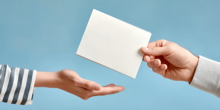 Business envelope exchange between two hands on blue background conveying communication and trust in corporate correspondenceの素材