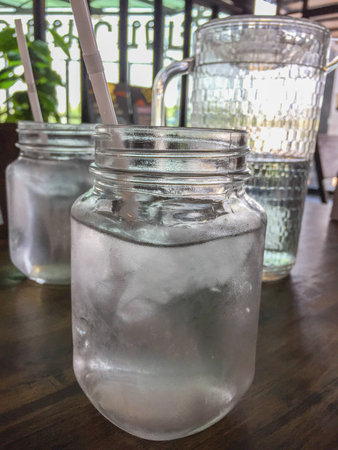 Vintage cold glass of water on wooden table at restaurant.の写真素材