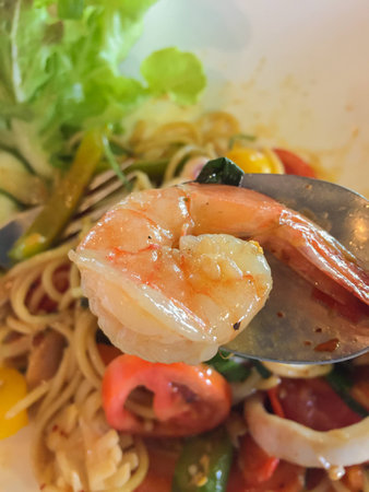 close up of srimp on spoon. Stir-fried Spicy Spaghetti Seafood Thai Style (Pad Kee-Mao Spaghetti).の写真素材